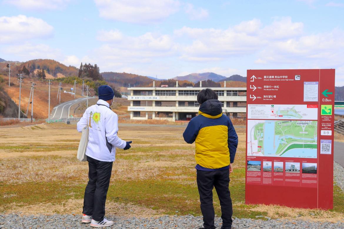 震災遺構 気仙中学校でパークガイドがお話する様子